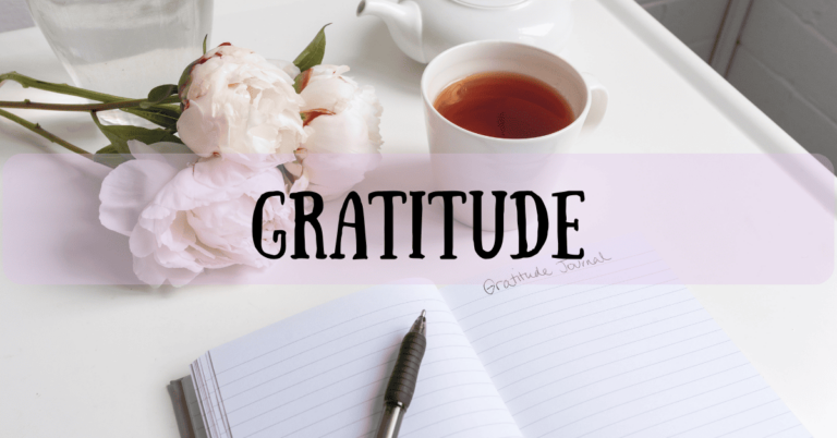 Gratitude journal with pen, tea, and flowers - featured image for gratitude journaling blog post
