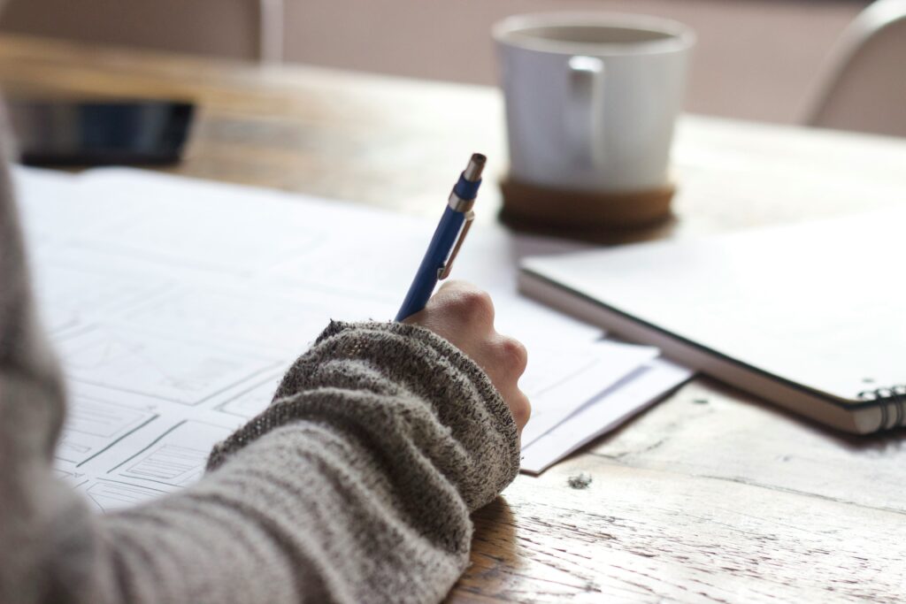 Gratitude Journaling with hand on page of notebook